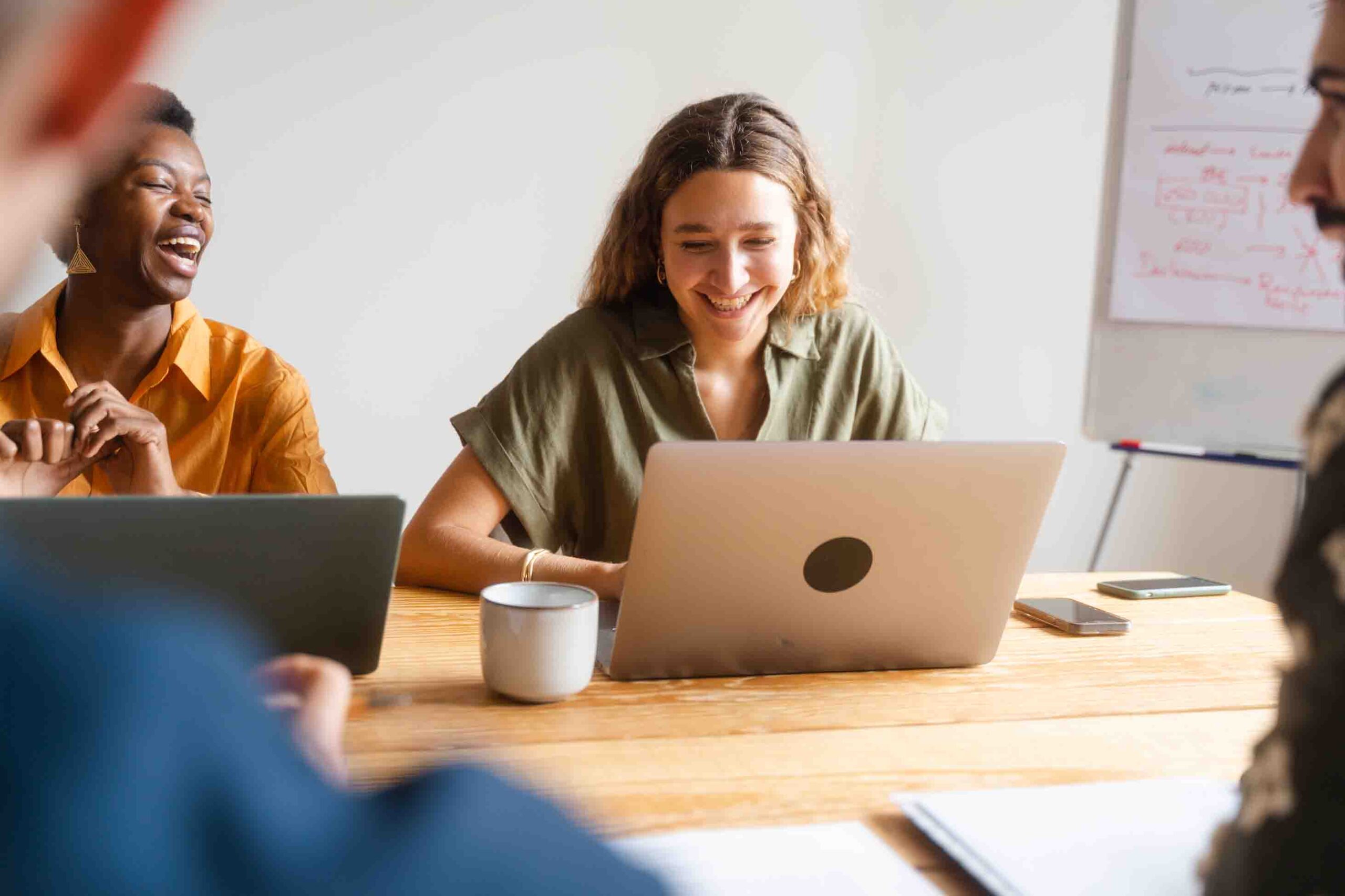 A woman on a meeting looking to her computer and laughing